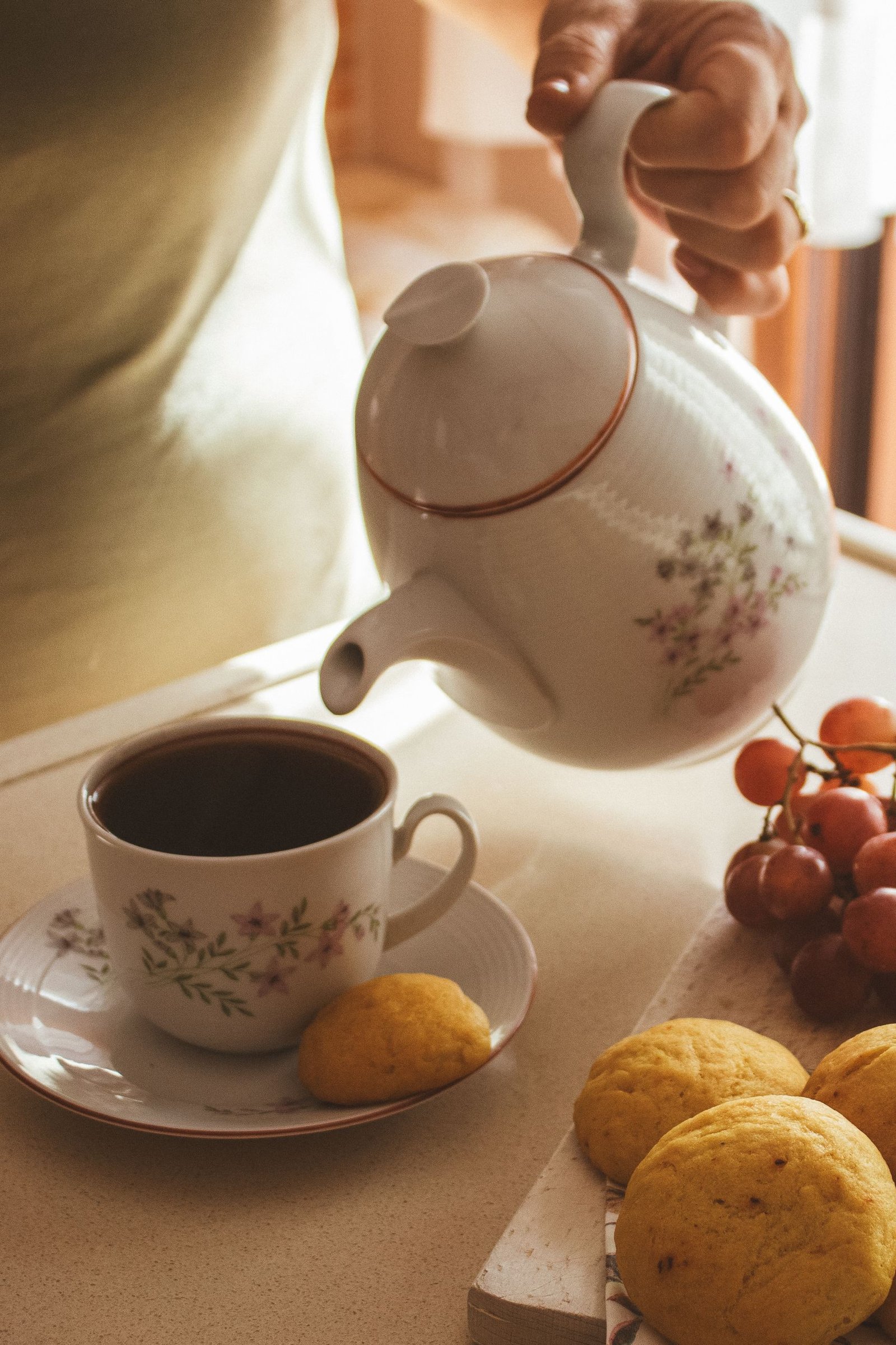 A warm cup of tea served with cookies and fresh grapes for a relaxing afternoon.